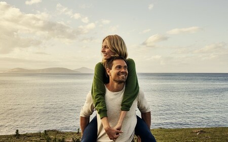 Girl sitting guys back by water