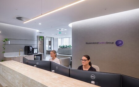 two receptionists looking at screen smiling in new fertility clinic
